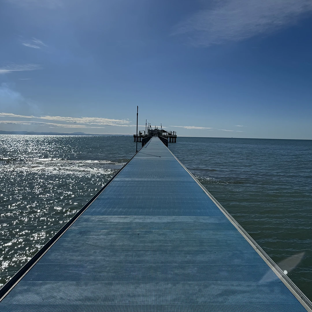 Si vede la passerella sospesa sul mare che dalla spiaggia porta alla Pagoda in una calda giornata di sole